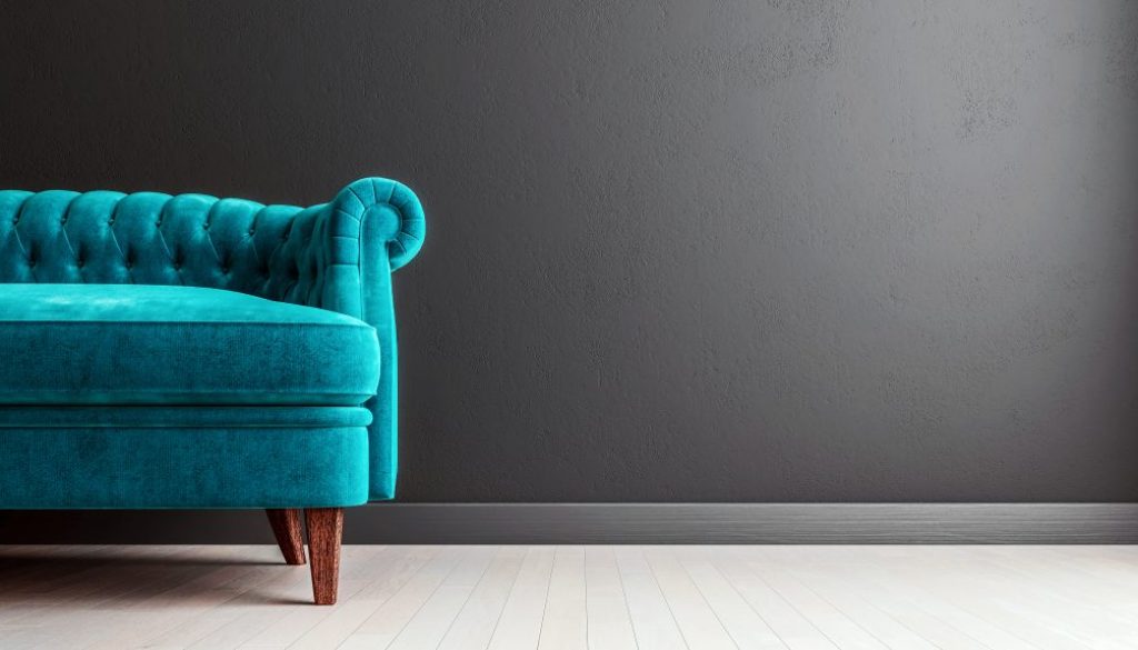 Living room dark grey interior wall mock up with turquoise blue colored velvet sofa, empty grey wall with free space on the right, 3D render, 3D illustration