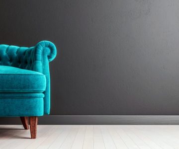 Living room dark grey interior wall mock up with turquoise blue colored velvet sofa, empty grey wall with free space on the right, 3D render, 3D illustration