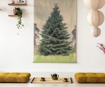 Real photo of two tatami mats with a pot and teacups between in a japanese room interior with big tree painting on a wall